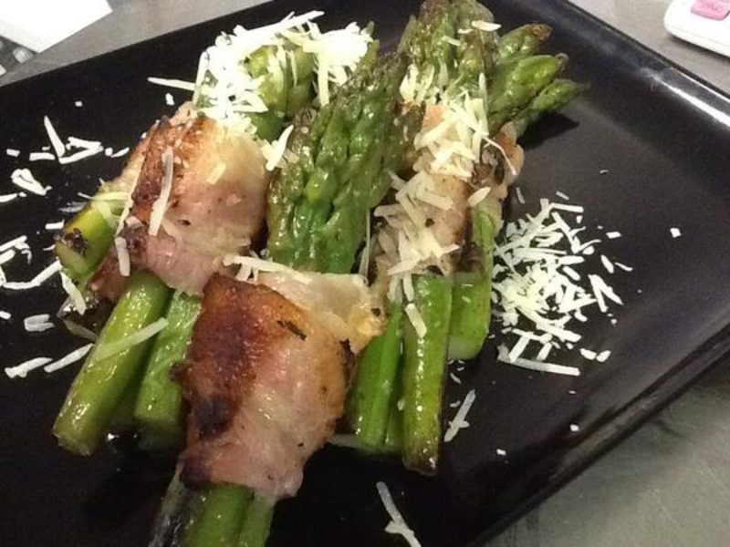 Fresh asparagus wrapped in Parma ham with fresh Parmesan